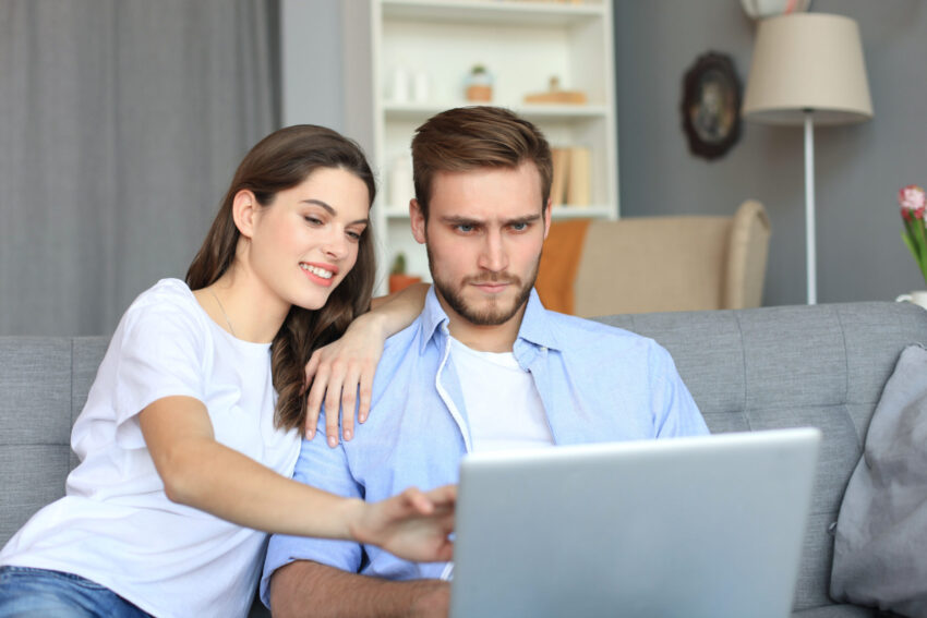 Junges Paar beim Online-Shopping schaut kritisch auf dem Laptop