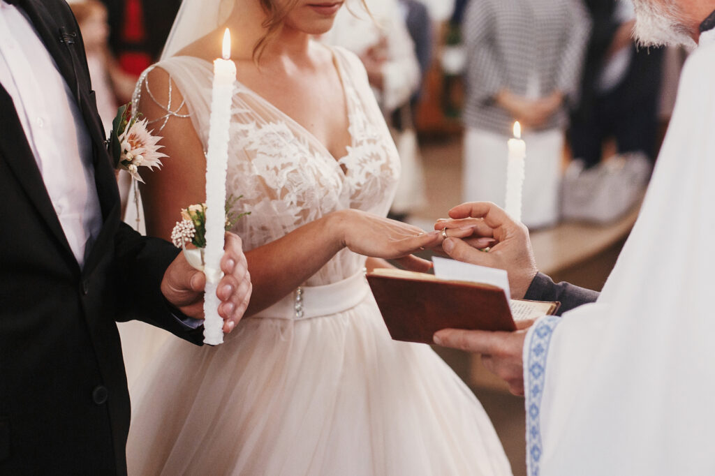 Der Priester übergibt der Braut den Ehering für den Ringtausch.