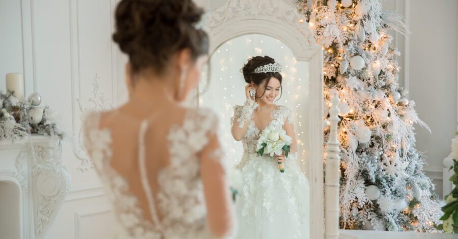 Heiraten an Weihnachten: Braut lächelt glücklich in den Spiegel