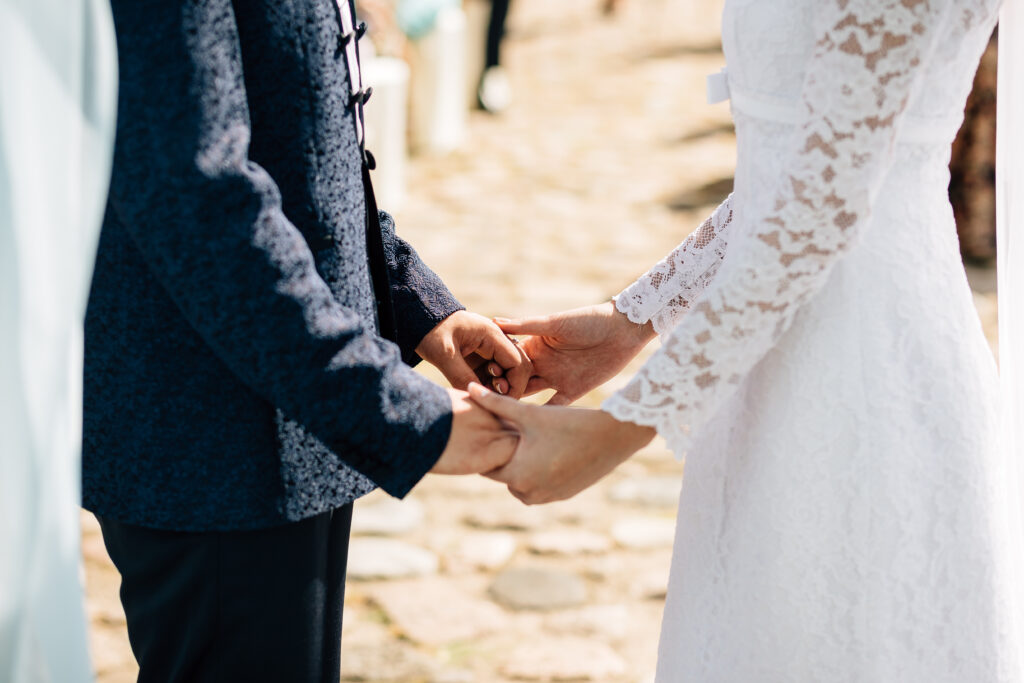 Hochzeitspaar hält Händchen während der Trauung